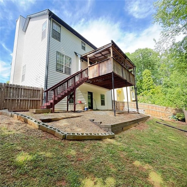 rear view of house featuring a deck, a fenced backyard, a patio area, a yard, and stairway