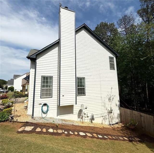back of property with fence and a chimney