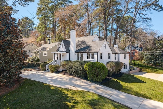 view of front of house with a residential view, a chimney, a front lawn, and stucco siding