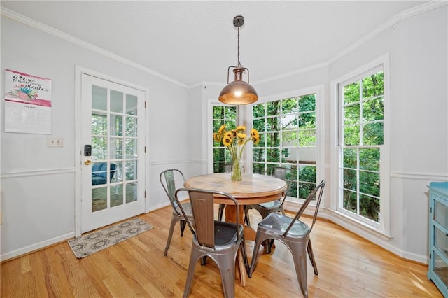 dining room with crown molding and light wood-style floors