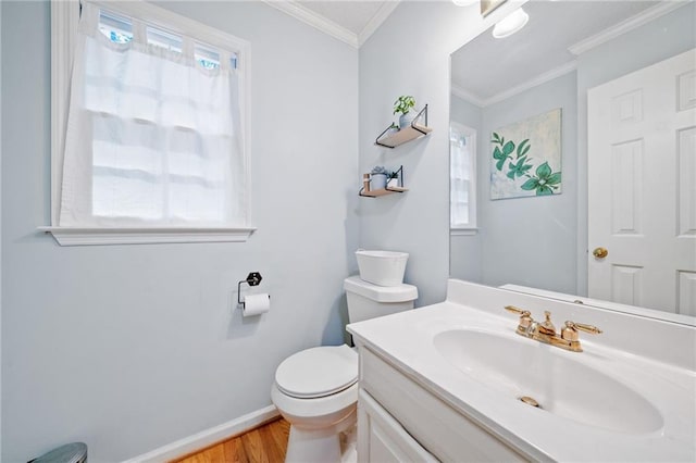bathroom featuring toilet, wood finished floors, vanity, baseboards, and ornamental molding