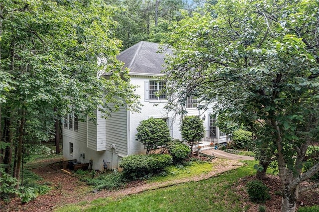 view of side of property with roof with shingles