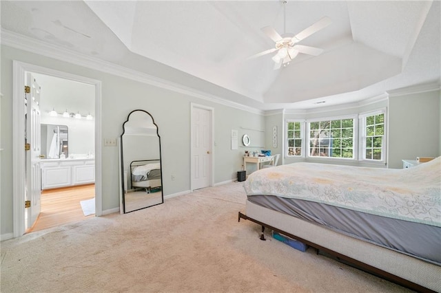 carpeted bedroom with a raised ceiling, baseboards, crown molding, connected bathroom, and ceiling fan
