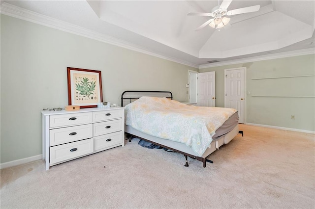 bedroom featuring a tray ceiling, light carpet, crown molding, baseboards, and a ceiling fan