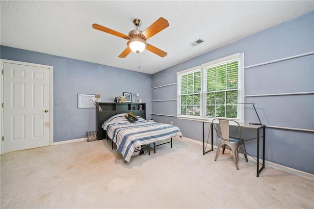 carpeted bedroom with baseboards, ceiling fan, and a textured ceiling
