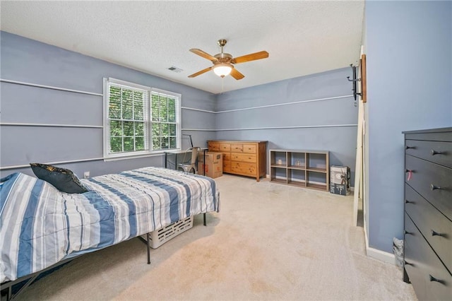carpeted bedroom featuring a textured ceiling and ceiling fan