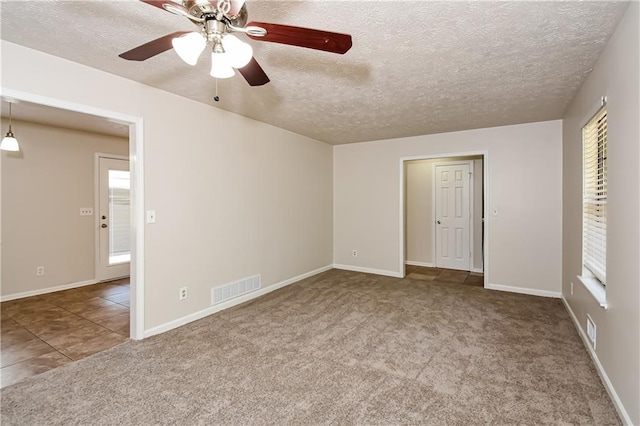 unfurnished bedroom with ceiling fan, carpet floors, a textured ceiling, and multiple windows