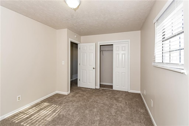 unfurnished bedroom featuring a closet, carpet, and a textured ceiling