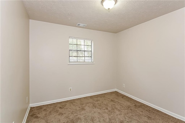 carpeted empty room with a textured ceiling