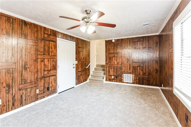 unfurnished bedroom with carpet, a textured ceiling, and multiple windows