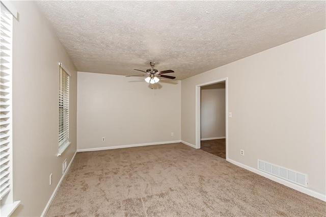 empty room featuring carpet flooring, ceiling fan, and a textured ceiling