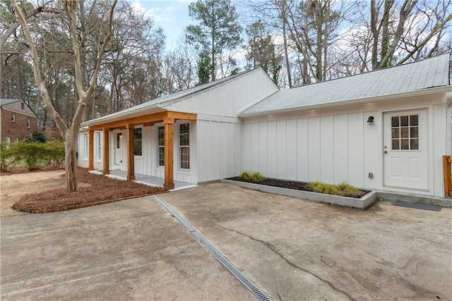 property entrance with covered porch and board and batten siding