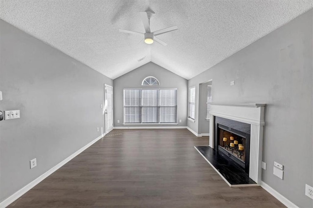 unfurnished living room with ceiling fan, dark wood-type flooring, a textured ceiling, and lofted ceiling