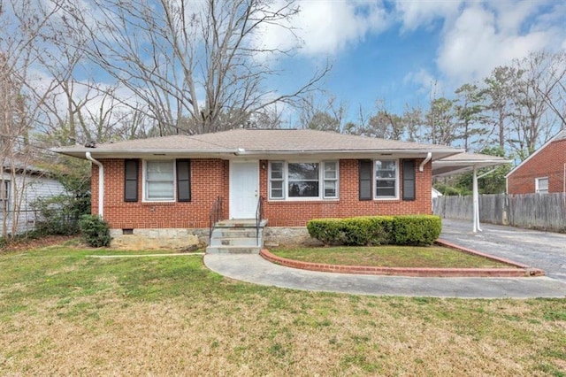 view of front facade with brick siding, an attached carport, driveway, and fence