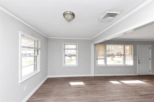 spare room with visible vents, ornamental molding, and wood finished floors