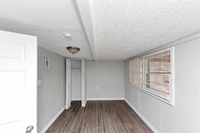 unfurnished room with wood finished floors, baseboards, and a textured ceiling