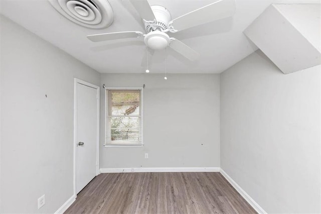 unfurnished room featuring ceiling fan, baseboards, and wood finished floors