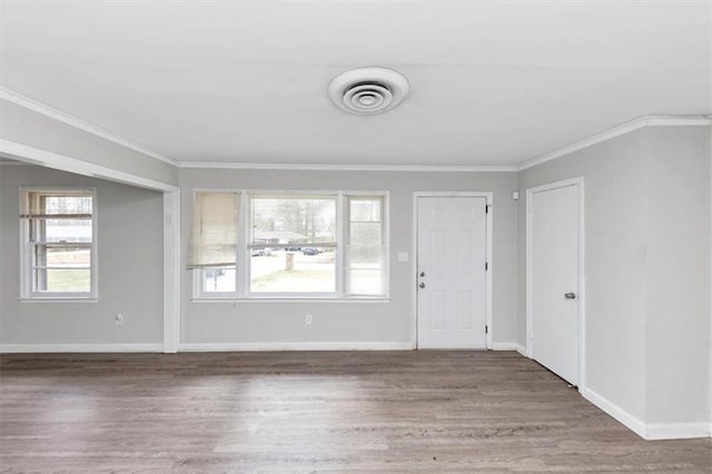 interior space featuring plenty of natural light, wood finished floors, visible vents, and ornamental molding