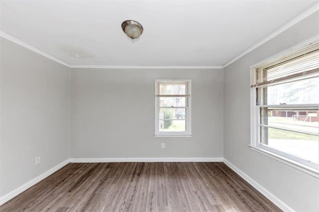 empty room with crown molding, baseboards, and wood finished floors