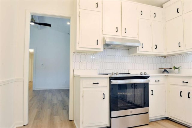 5974 SW Four Winds Dr SW, Lilburn, GA 30047 - kitchen featuring stainless steel electric stove, under cabinet range hood, light countertops, decorative backsplash, and light wood-type flooring