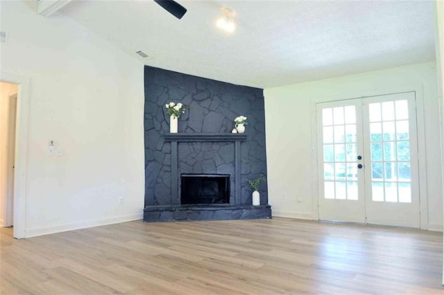 5974 SW Four Winds Dr SW, Lilburn, GA 30047 - unfurnished living room featuring vaulted ceiling, wood finished floors, a fireplace, french doors, and a textured ceiling
