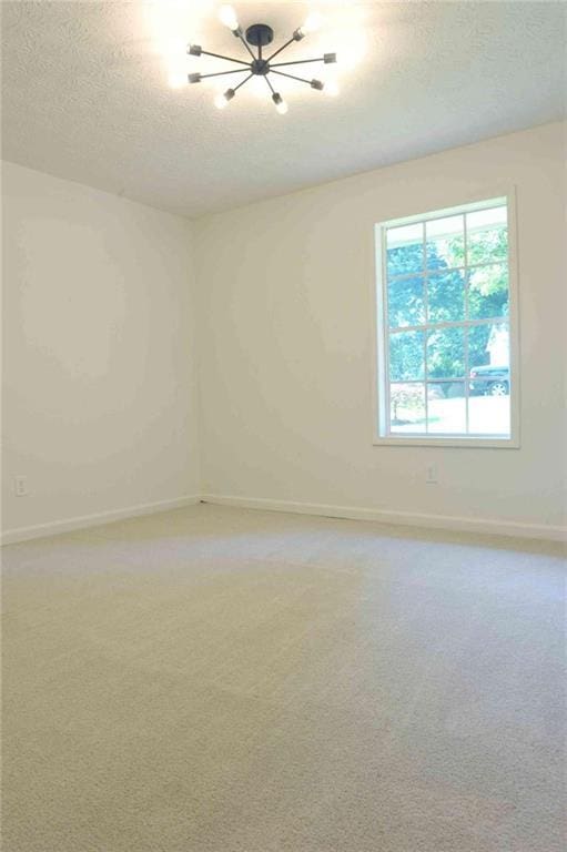 5974 SW Four Winds Dr SW, Lilburn, GA 30047 - empty room with a chandelier, a textured ceiling, and light carpet