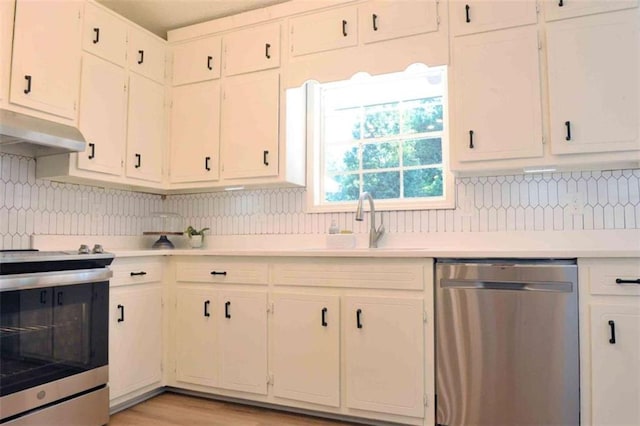 5974 SW Four Winds Dr SW, Lilburn, GA 30047 - kitchen with appliances with stainless steel finishes, under cabinet range hood, light countertops, and backsplash
