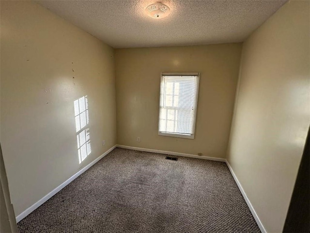 empty room featuring carpet and a textured ceiling