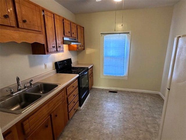 kitchen with electric range, sink, white fridge, and pendant lighting