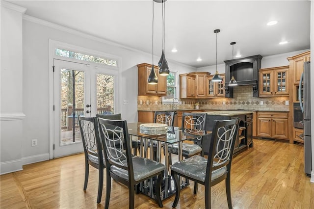 dining area featuring light wood-style floors and ornamental molding