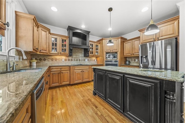 kitchen featuring a sink, stainless steel appliances, brown cabinetry, and crown molding