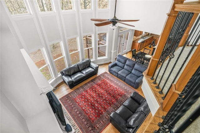 living room featuring stairway, wood finished floors, and ceiling fan