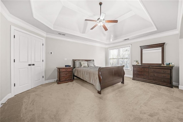 bedroom with a tray ceiling, baseboards, visible vents, and carpet floors