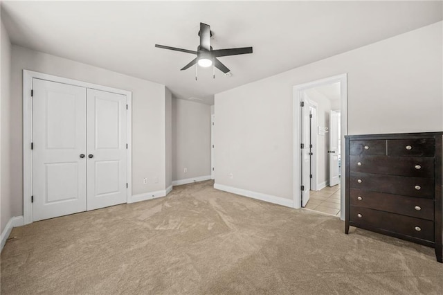 unfurnished bedroom featuring carpet flooring, baseboards, a closet, and ceiling fan