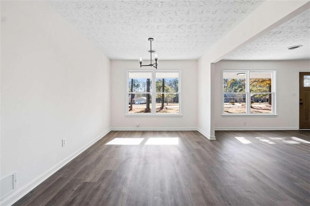 unfurnished dining area with a textured ceiling, an inviting chandelier, and plenty of natural light