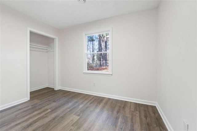 unfurnished bedroom featuring a closet and dark hardwood / wood-style flooring