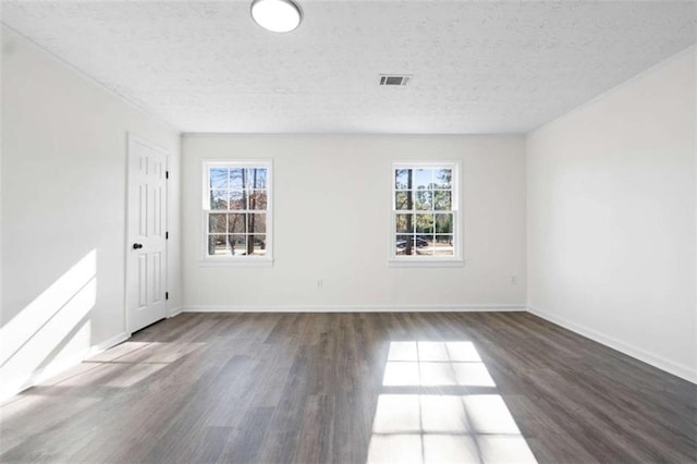 spare room with dark wood-type flooring and a textured ceiling