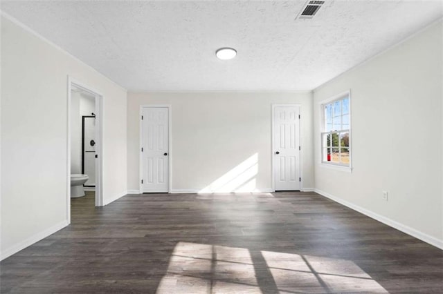 unfurnished room with a textured ceiling and dark hardwood / wood-style floors