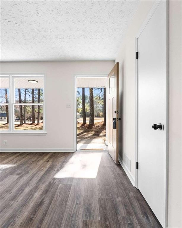 interior space with a textured ceiling and dark wood-type flooring