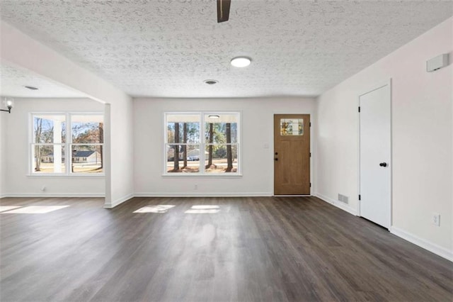 foyer entrance featuring a textured ceiling and dark hardwood / wood-style flooring