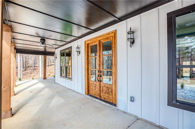 property entrance featuring board and batten siding, french doors, covered porch, and a ceiling fan