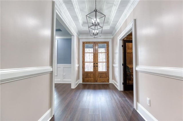 entrance foyer featuring a chandelier, dark wood-type flooring, french doors, ornamental molding, and a tray ceiling