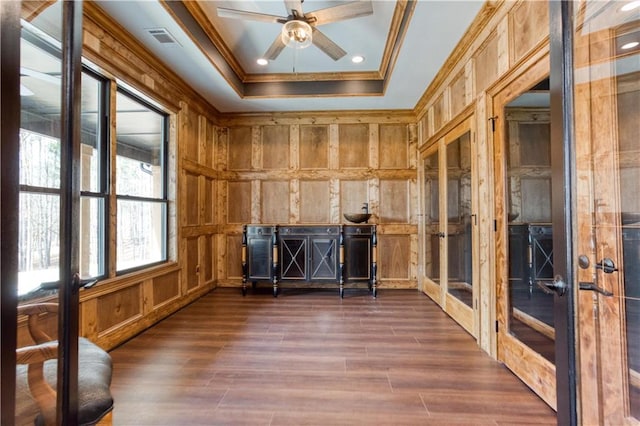 interior space featuring french doors, visible vents, ornamental molding, dark wood-type flooring, and wooden walls