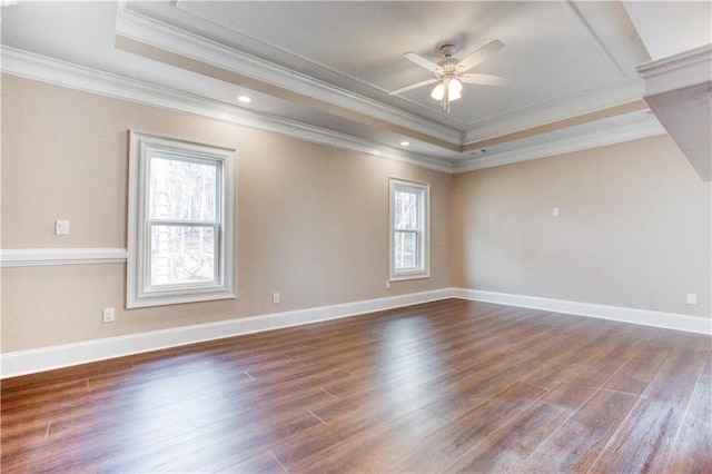 spare room with baseboards, a raised ceiling, dark wood-style floors, ceiling fan, and crown molding