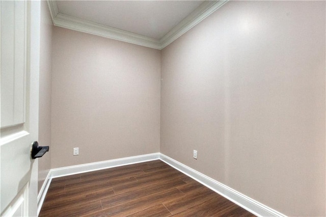 empty room featuring ornamental molding, dark wood finished floors, and baseboards