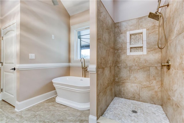 bathroom featuring a freestanding tub, a tile shower, and baseboards