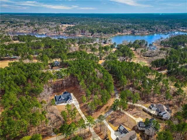 drone / aerial view featuring a water view and a wooded view