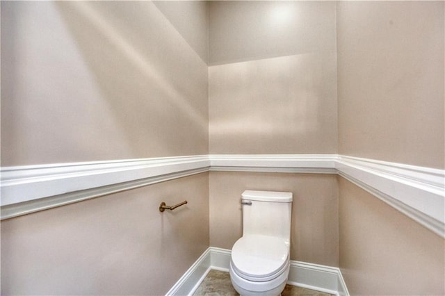 bathroom with baseboards and toilet