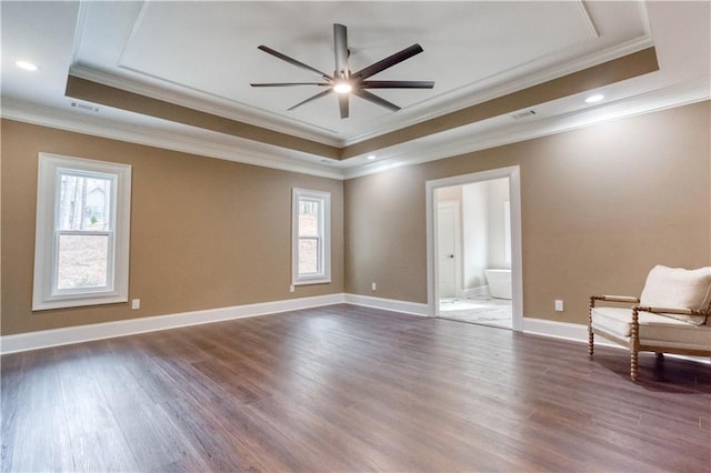 unfurnished room featuring dark wood-type flooring, a raised ceiling, and a wealth of natural light