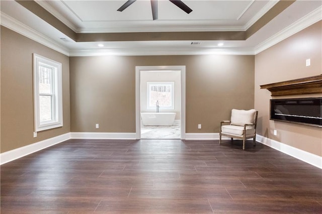 unfurnished room with a raised ceiling, baseboards, crown molding, and dark wood-style flooring